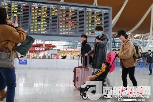 旅客帶著孩子前往辦票柜臺(tái)辦理登機(jī)手續(xù)?！∫罅⑶?攝