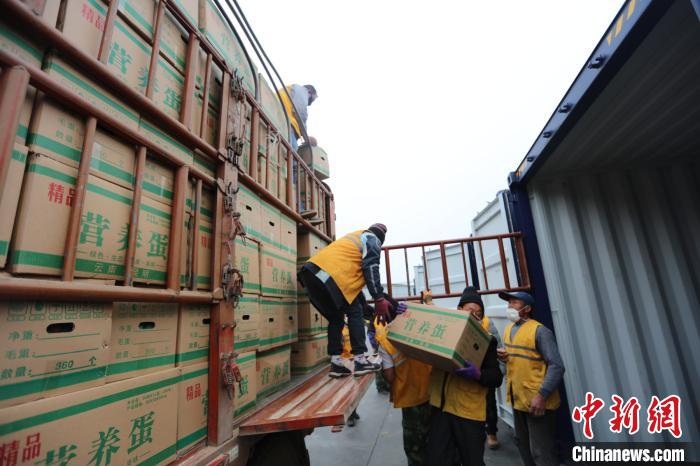 圖為鐵路裝卸作業(yè)人員正在將云南特色農(nóng)產(chǎn)品裝入集裝箱?！詈?攝