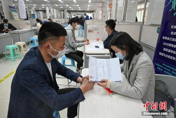 4月14日，招聘者在查看求職者簡歷。<a target='_blank'  data-cke-saved- >中新社</a>記者 王剛 攝