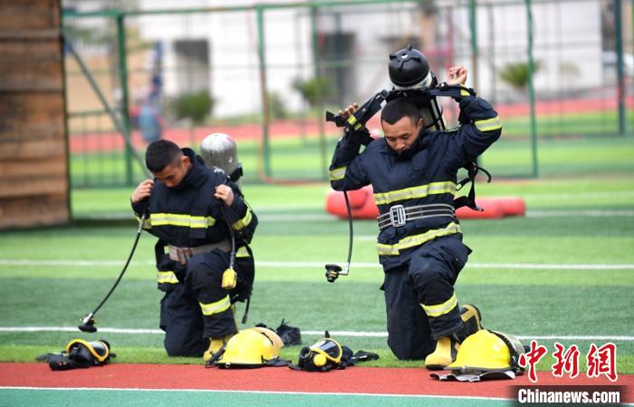 新消防員進(jìn)行穿戴空呼器展示?！⒅铱?攝