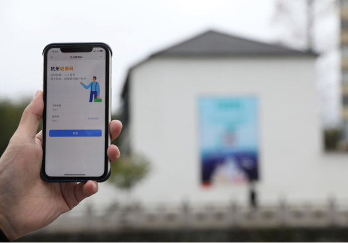 在浙江省杭州市臨安區(qū)天目山鎮(zhèn)，一名居民在“杭州健康碼”海報(bào)上掃碼申領(lǐng)個(gè)人二維碼。新華社發(fā)