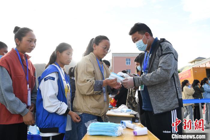 7月7日，考生在拉薩三高考點(diǎn)外領(lǐng)取口罩?！『闻罾?攝