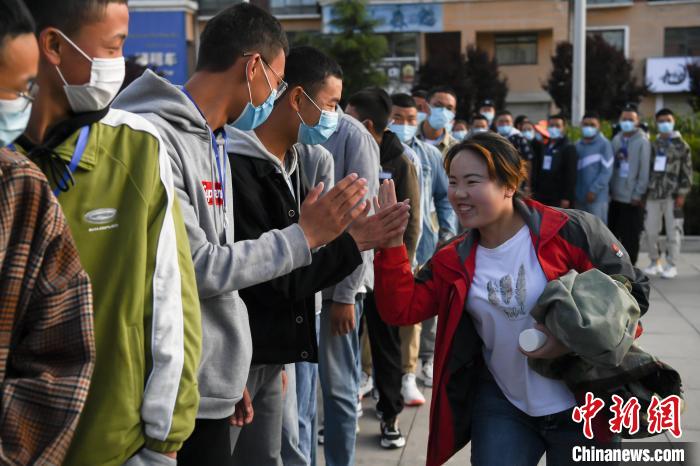 7月7日，拉薩三高考點(diǎn)外，領(lǐng)隊(duì)老師與考生擊掌鼓勁加油。　何蓬磊 攝