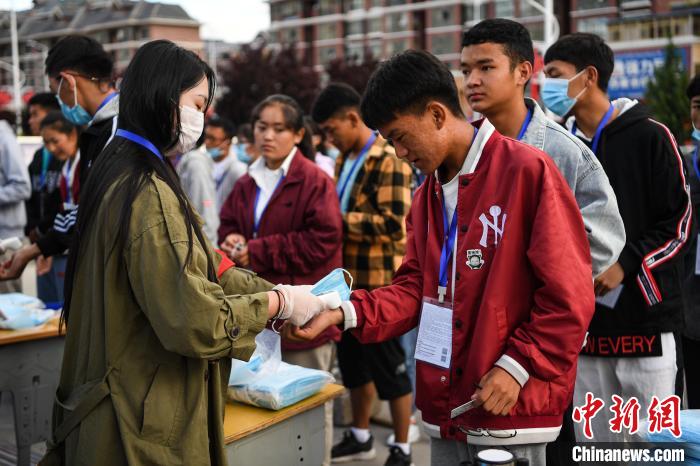 7月7日，考生在拉薩三高考點(diǎn)外測(cè)量體溫?！『闻罾?攝